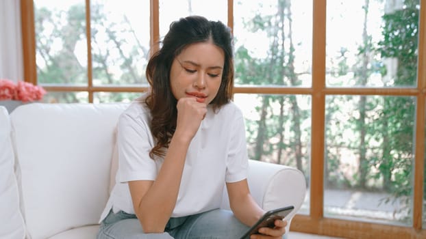 Young woman using smartphone browsing for online shopping E commerce by online payment gateway at vivancy home. Modern and convenience online purchasing make secure and convenient purchases.