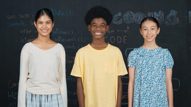Multicultural smart people smiling at camera at blackboard with prompt or code. Group of diverse friend with mixed races standing together at STEM class with idea or program develop plan. Edification.