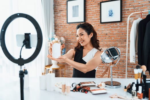 Woman influencer shoot live streaming vlog video review makeup uttermost social media or blog. Happy young girl with cosmetics studio lighting for marketing recording session broadcasting online.