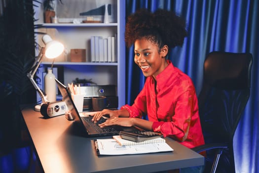 African woman blogger wearing pink shirt with happy face, looking on screen laptop with valued achievement project or get scholarship. Concept of cheerful expression work from home. Tastemaker.