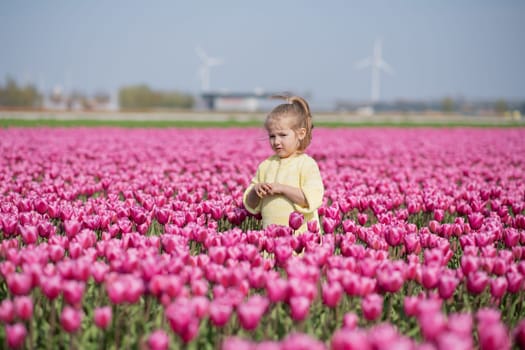 Happy girl in a pink tulip field