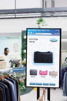 Modern self ordering kiosk display with different fashion items for clients to choose and purchase, self service concept. Interactive touch screen board clothes selection, e commerce.