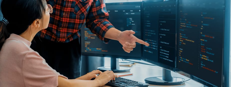 Cropped image of professional programer team collaboration discuss about web coding while coworker point java script displayed on computer at modern company office. Closeup. Burgeoning.