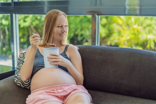 Happy pregnant young woman eating ice cream.