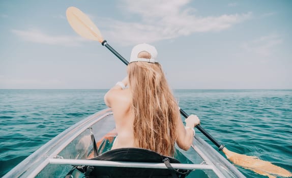 Woman in kayak back view. Happy young woman with long hair floating in transparent kayak on the crystal clear sea. Summer holiday vacation and cheerful female people having fun on the boat.