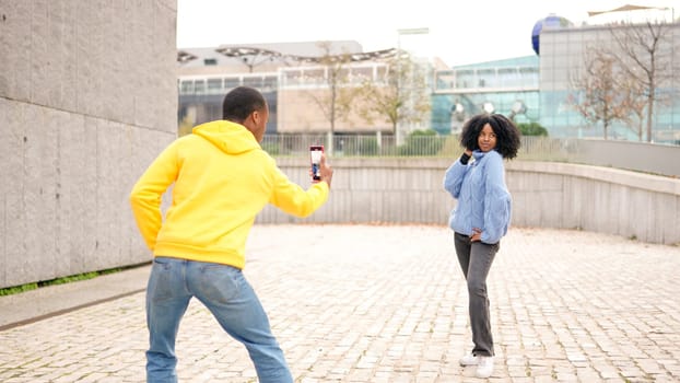 African woman posing while her couple taking photos of her outdoors