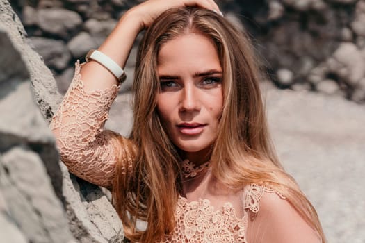 Woman travel sea. Young Happy woman in a long red dress posing on a beach near the sea on background of volcanic rocks, like in Iceland, sharing travel adventure journey