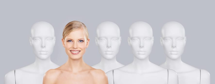 Woman, mannequins and smile for identity, beauty and individuality on studio background. Person, skincare and dummy with face for creativity and cosmetics or unique ideas for satisfaction and skin.