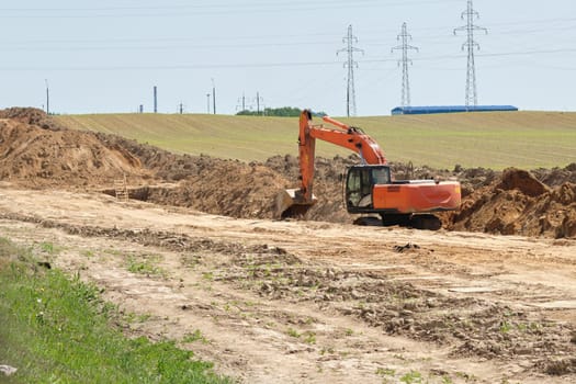 Excavator digs a trench for laying pipes, cable