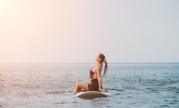 Sea woman sup. Silhouette of happy young woman in pink bikini, surfing on SUP board, confident paddling through water surface. Idyllic sunset. Active lifestyle at sea or river. Slow motion