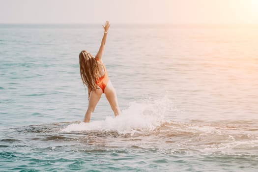 Woman sea yoga. Back view of free calm happy satisfied woman with long hair standing on top rock with yoga position against of sky by the sea. Healthy lifestyle outdoors in nature, fitness concept.