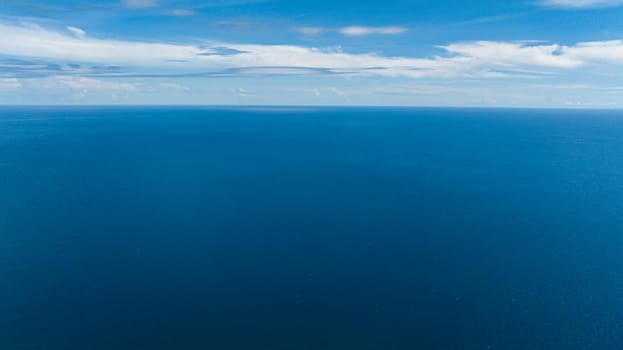 Blue sea water with waves against sky and clouds. Seascape in the tropics. Borneo, Malaysia.