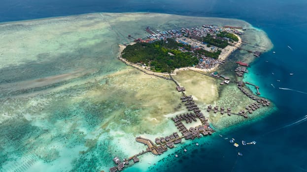 Tropical island Mabul in the blue sea with a coral reef and the beach. Semporna, Sabah, Malaysia.