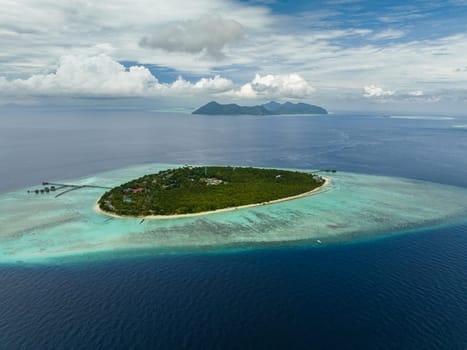 Aerial drone of island with beach and coral reef in the tropics. Pom Pom islet. Tun Sakaran Marine Park. Borneo, Sabah, Malaysia.