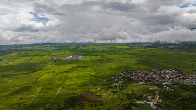 Top view of valley with tea plantations and farmland in the highlands. Kayu Aro, Sumatra, Indonesia.