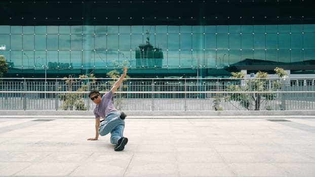 Skilled asian hipster posing and looking at camera at city urban. Panorama shot of professional street dancer practice b-boy footstep or break dance. Modern lifestyle. Outdoor sport 2024. Sprightly.