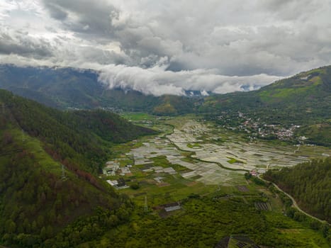 Top view of farmland and town in the valley among the mountains. Sumatra, Indonesia.