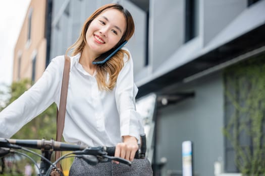 On a bike ride a businesswoman stays connected with her smartphone displaying the modern concept of work-life balance. Her joyful expression reflects the harmony between work and leisure.