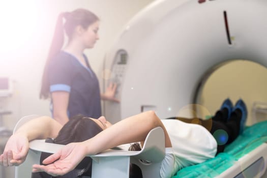 A woman lies on the tomograph table. woman is undergoing computed axial tomography examination in a modern hospital.