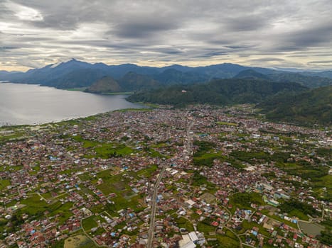 Aerial view of Takengon city in mountains among farmland and Laut tawar lake. Sumatra, Indonesia.