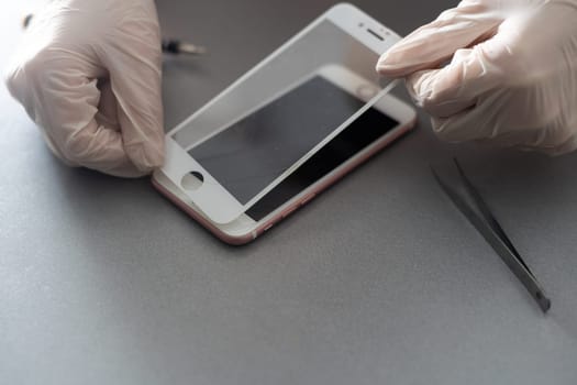 a person places a protective glass or film on a smartphone. copy space