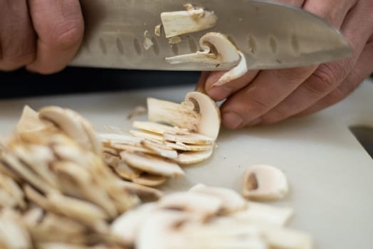 hands men cut the mushrooms for the pizza on the Board. High quality photo