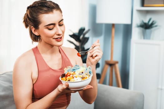 Healthy sporty and vegetarian woman in sportswear with a bowl of fruit and vegetable. Healthy cuisine nutrition and vegan lifestyle for fitness body physique at gaiety home concept.