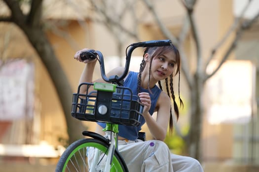 Happy Asian young woman ride bicycle in park, street city her smiling using bike of transportation, ECO friendly, People lifestyle concept.