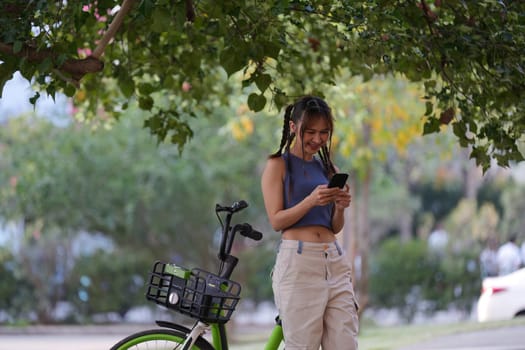 Happy Asian young woman ride bicycle in park, street city her smiling using bike of transportation, ECO friendly, People lifestyle concept.