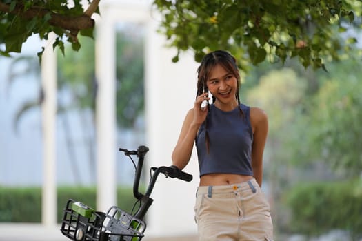 Happy Asian young woman ride bicycle in park, street city her smiling using bike of transportation, ECO friendly, People lifestyle concept.