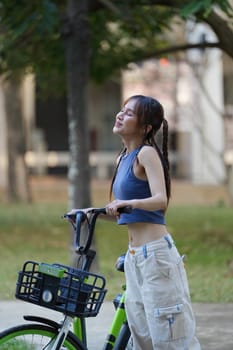 Happy Asian young woman ride bicycle in park, street city her smiling using bike of transportation, ECO friendly, , People eco lifestyle concept.
