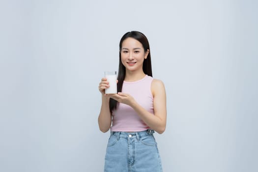 Young smiling happy fun woman hold in hand glass drink milk isolated on white background.