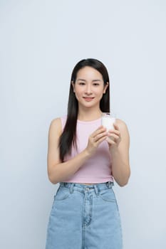 Young woman enjoying a glass of milk isolated over white background