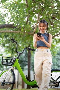 Happy young asian woman in casual clothes enjoy riding bicycle at the park for recreation.