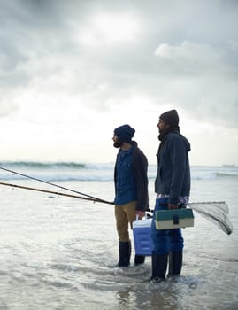 Fisherman, friends and gear on beach for fishing in the morning by sea with overcast, equipment and sky. Friendship, men and net with bonding, travel or rod by water for hobby, holiday or activity.