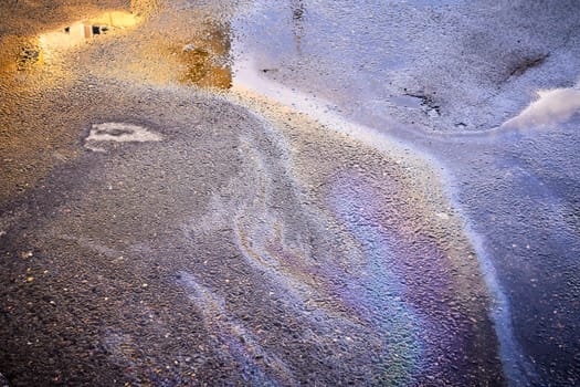 A colorful stain of engine oil on the road
