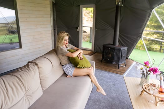 Pretty young caucasian woman resting in glamping outside city. Relaxation concept.