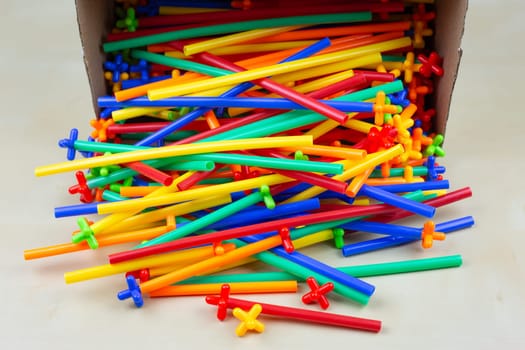 Multi colored tubes of special modern constructor poured out of a box, plastic parts for playing with a child