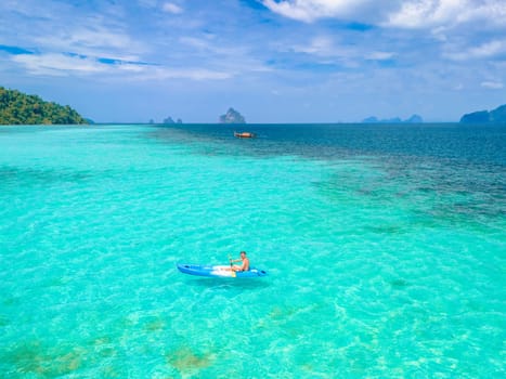 Young men in a kayak at the bleu turqouse colored ocean of Koh Kradan Thailand, a tropical island with a coral reef in the ocean, Koh Kradan Trang Thailand