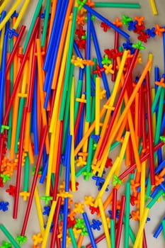 Flexible construction set tubes with special connection are scattered on the table, mess on the children play area in the room, modern construction set