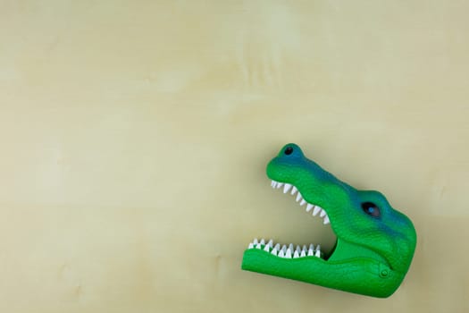 Dinosaur head toy on table with space for text, concept of children toy with animal