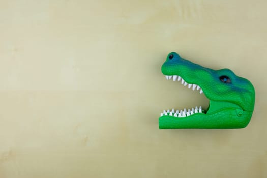 Dinosaur head toy with open mouth, children favorite dinosaur toy, plastic green head of extinct reptile