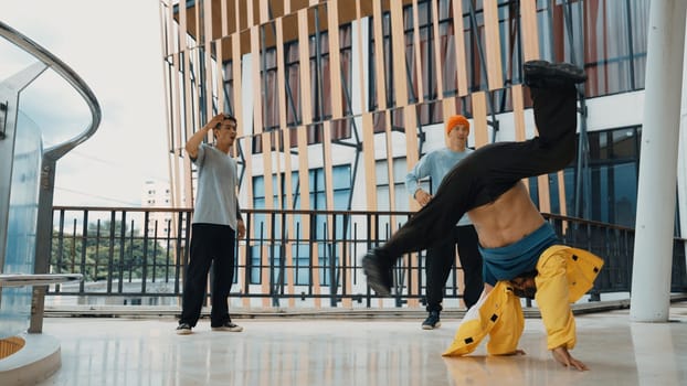 Hip hop team dance break dance while multicultural friend surrounded and clapping hands to cheer or encourage his friend to dance. Active and energetic street dance. Outdoor sport 2024. Endeavor.