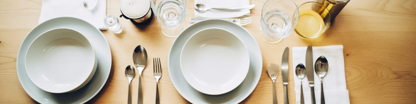 A wooden table topped with white plates and silverware