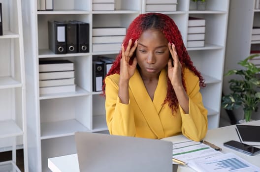 African American businesswoman has fatigue and headaches from working in the office..