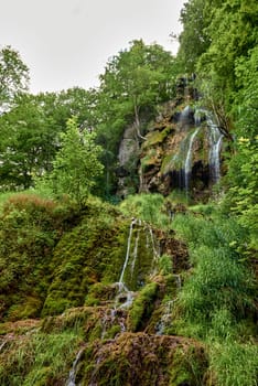 Majestic Cascade: Uracher Wasserfall Amidst Verdant Forest Landscape.