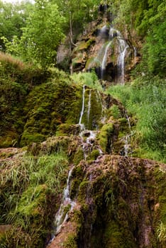 Waterfall Bad Urach at Southern Germany Longexposure. Cascade panorama in Bad Urach Germany is a popular natural attraction and waterfall sight called Uracher Wasserfall . Natural reserve in autumn season with colorful foliage and longtime exposure. Panoramic view of Bruehlbach creek or brook with cascade in Bad Urach, Germany near waterfall sight Uracher Wasserfall . Natural reserve on a summer morning after heavy rain in lush forest.