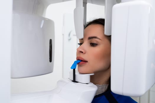 Close up portrait of young woman having panoramic X ray of her teeth in dentist office.