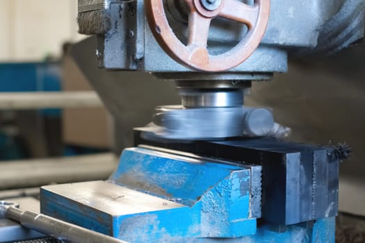 Old CNC milling machine for cutting stainless steel metal workpiece. Close-up of a cutter in action.