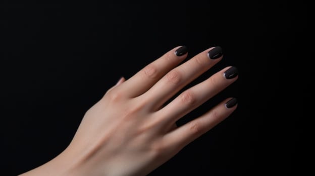 A woman's hand with black nail polish and a manicure